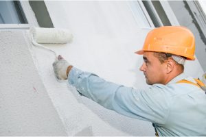 Exterior Painter with a worker wearing a hard hat and a roller.