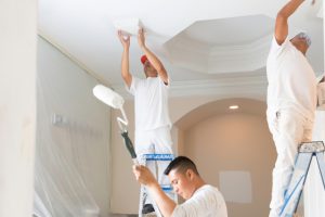 Painting ceiling in a bathroom by 3 workers.